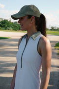 white maison merritt golf dress with green details. girl is laughing while wearing it. 